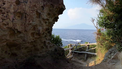 view through cove onto gulf of naples with boat going past