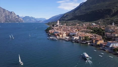 Toma-Aérea-Moviéndose-Hacia-Malcesine-En-El-Lago-Di-Garda-En-Un-Brillante-Día-Soleado-De-Verano