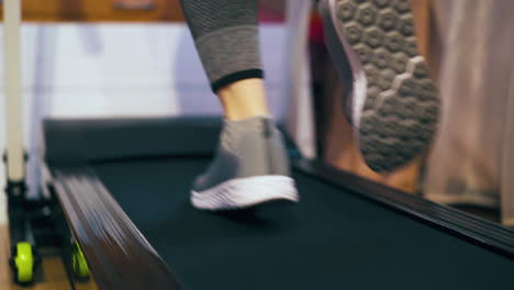 active-woman-runs-along-modern-athlete-track-in-room