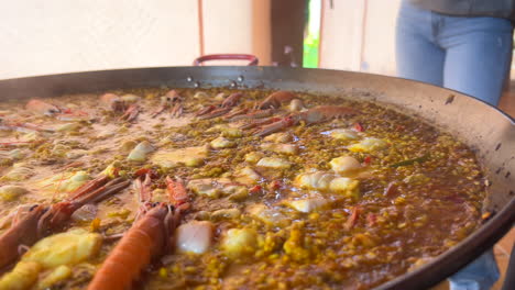preparing a traditional spanish seafood paella dish with shrimps, st jacques scallops and cigala norway lobsters nephrops norvegicus, cooked rice with seafood, marbella spain, 4k shot