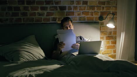 video of man lying in bed during working at night