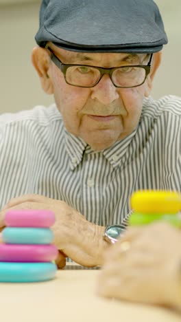 Elderly man playing stacking ring game