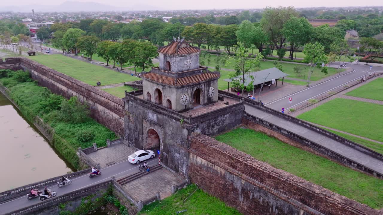 este metraje captura la entrada a la ciudad imperial de hue en vietnam, donde los vehículos modernos conducen hacia la puerta histórica