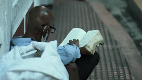 elderly man reading a book outdoors
