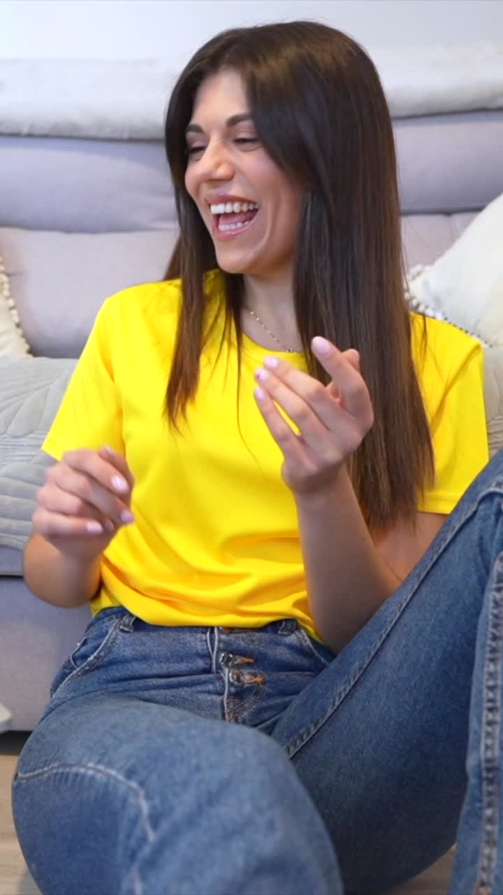 Woman smiling and sitting in front of a laptop at home