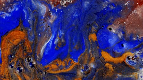 vivid blue and orange paint flows and mixes, creating abstract patterns in a macro view