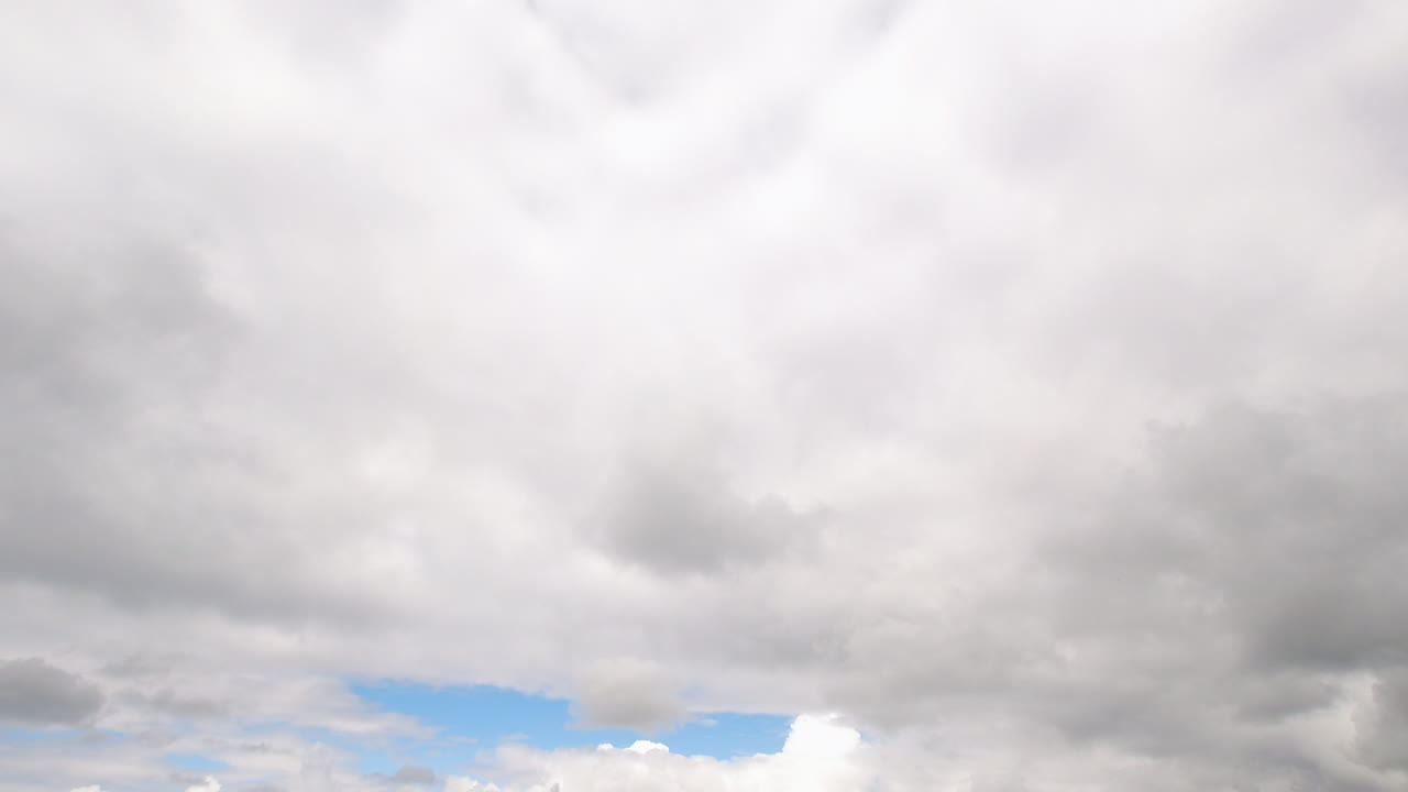 Timelapse of white clouds passing by and then turning very grey