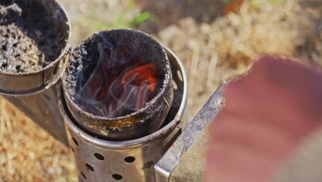 el apicultor prepara un fabricante de humo para las colmenas