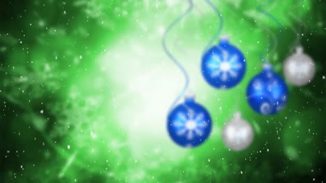 Animation-of-snowflakes-falling-over-blue-and-silver-baubles-on-green-background