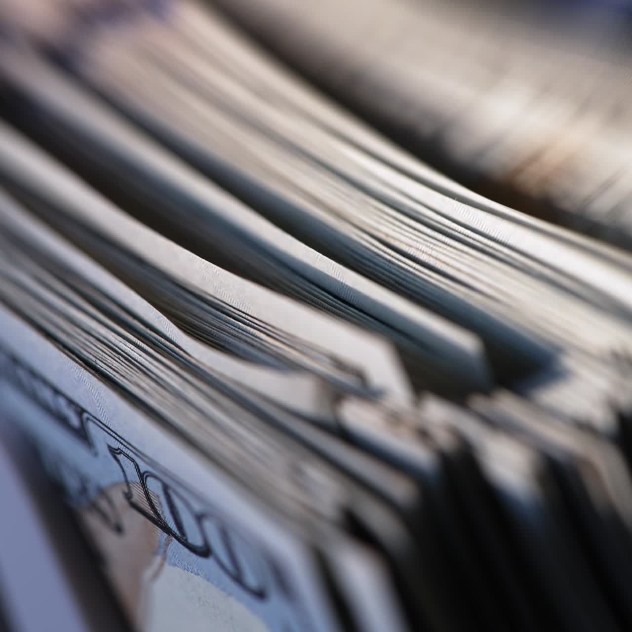 Hundred dollar bills wad turned quickly in machine. Cash counting device for financial operations. Close up