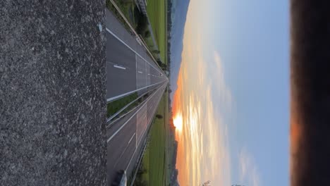 Video-De-Lapso-De-Tiempo-Vertical,-Autos-Conduciendo-En-Una-Carretera-Mientras-Se-Pone-El-Sol,-Suiza