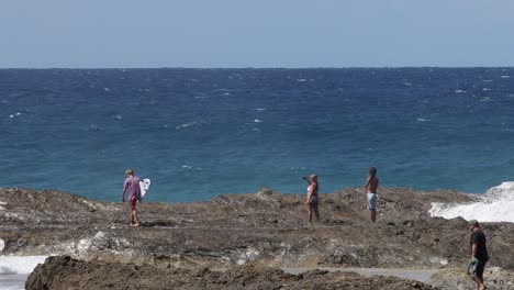 group of surfers entering and exiting ocean waves