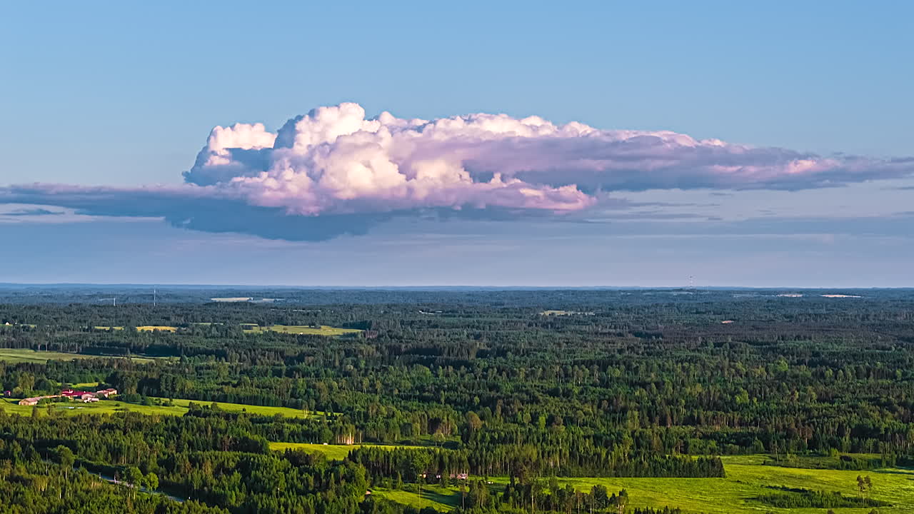 Clouds moving over a plain with trees. Time lapse