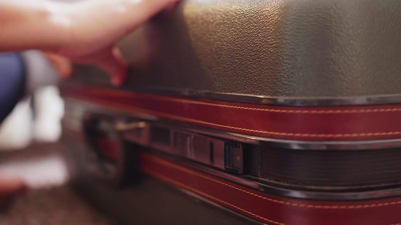 Detail of female hands closing suitcase with clothes