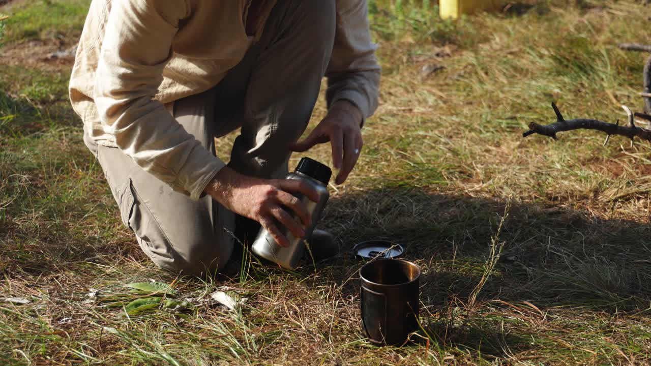 A western hiker boils up some water while camping in East Africa