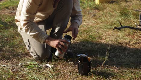 a western hiker boils up some water while camping in east africa