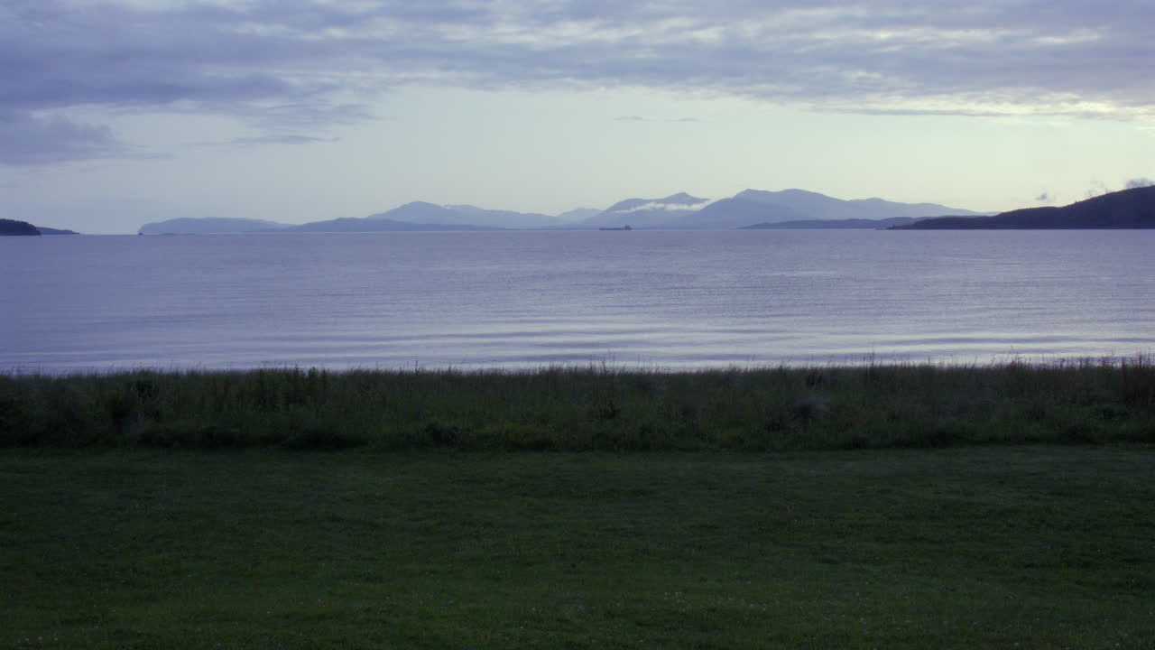 Extra Wide-bild av strand och Ardmucknish Bay i skymningen