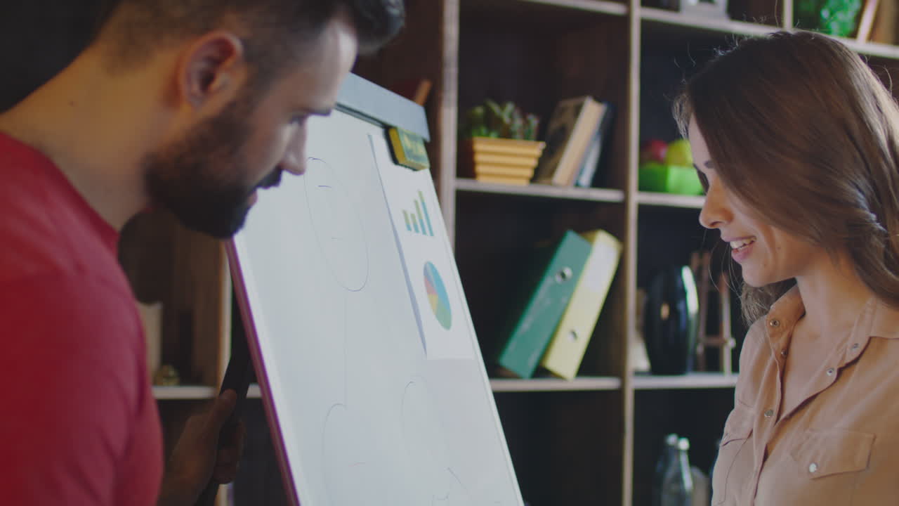 미소 짓는 여자 가 계획판 에 사업 전략 을 설명 하고 있다