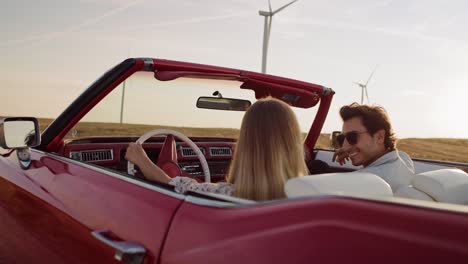 tracking video of man jump in red convertible