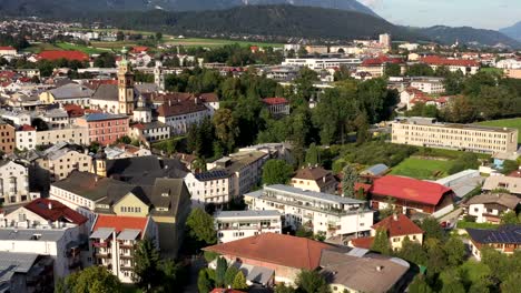 a drone shot of a town with houses, mountains and hills in the background