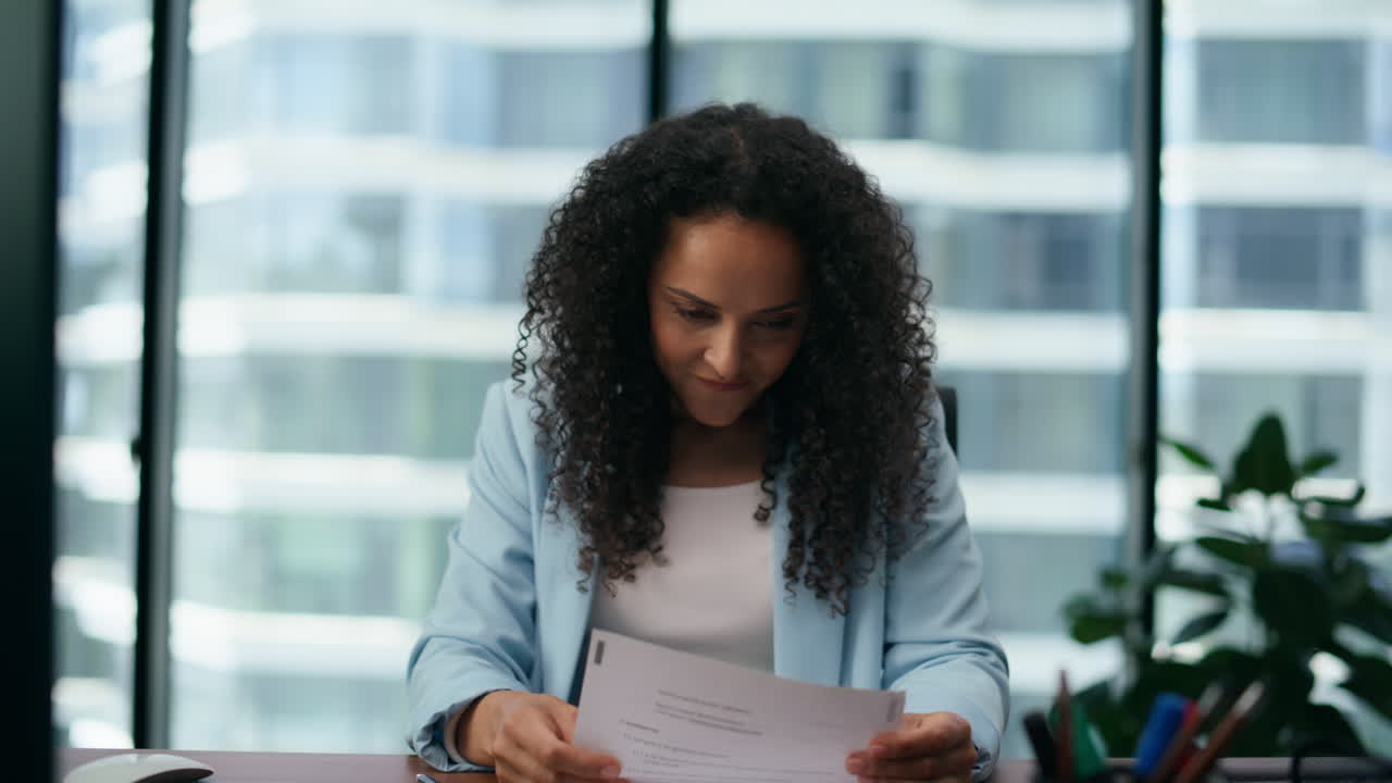 Latin businesswoman enjoying success in office closeup. Woman smiling satisfied