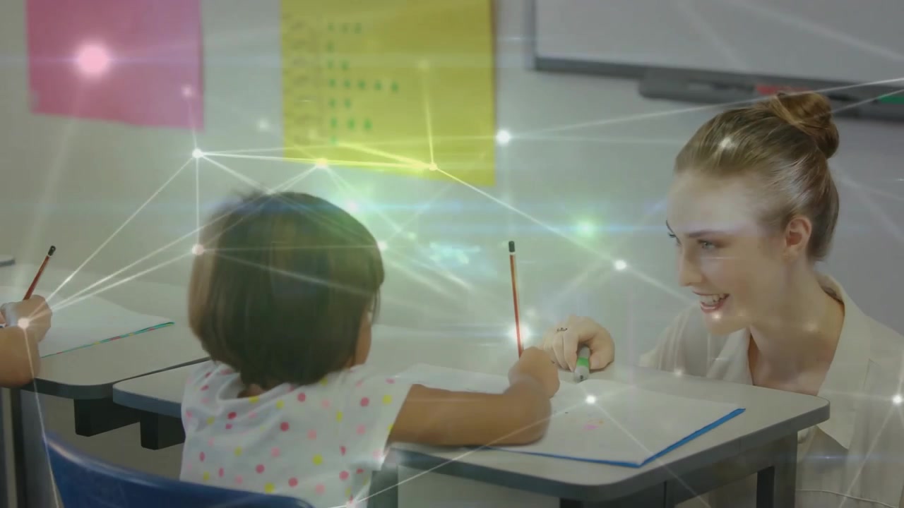 Educator kneeling beside student, guiding notebook writing, with floating book icons, in education