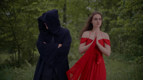 woman in red dress and reaper in woods