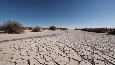 cracked desert landscape with small stream