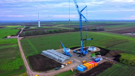 aerial view of a construction site with windmill turbine parts and machineries on the ground