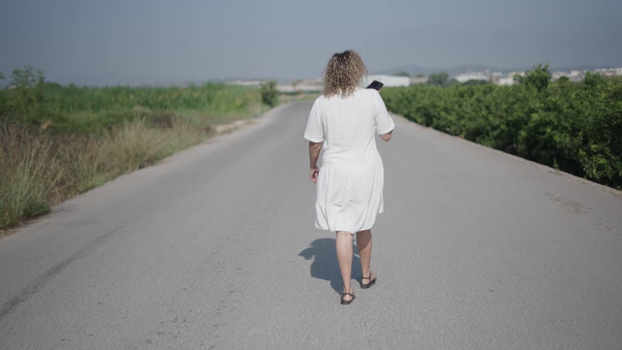 mujer caminando por un camino de campo