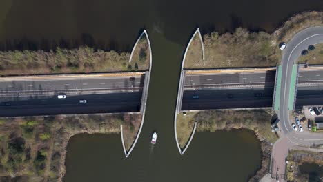 Topdown-view-Veluwemeer-Aqueduct,-boat-sailing-above-Traffic-in-highway,-The-Netherlands