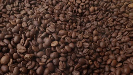 close up of seeds of coffee. fragrant coffee beans are roasted smoke comes from coffee beans.