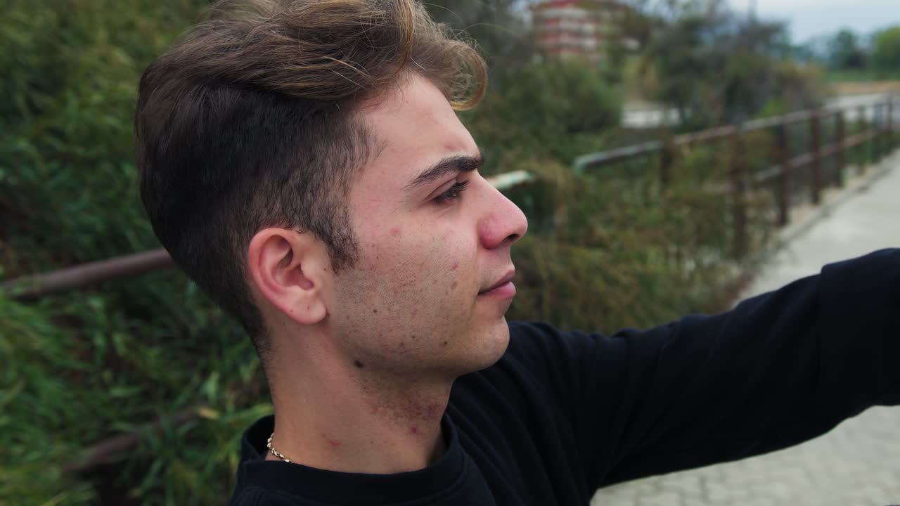 joven toma selfies de vanidad con su teléfono inteligente afuera en la naturaleza