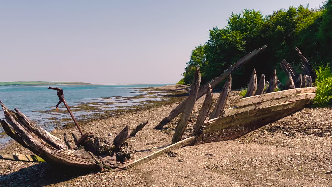 A 4k Drone shot in Ireland and at Fethard Saltmills beach Wexford of an abandoned wooden boat hull