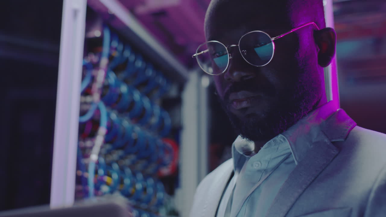 African American Data Center Engineer Working in Server Room