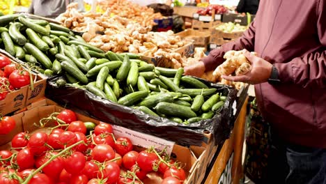 person selecting fresh produce at market stall