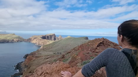 Cinematic-shot-of-a-woman-admiring-the-landscape-and-the-roads-of-Punta-de-San-Lorenzo-on-the-island-of-Madeira-and-on-a-sunny-day