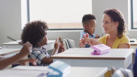 Video-of-happy-caucasian-female-teacher-learning-math-to-african-american-boy