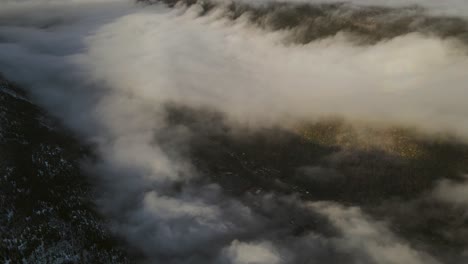 beautiful valley covered by clouds and a town visible trough the clouds