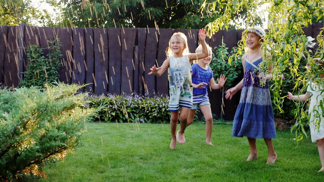 시냇물과 함께 정원에서 웃는 네 명의 평온한 아이들