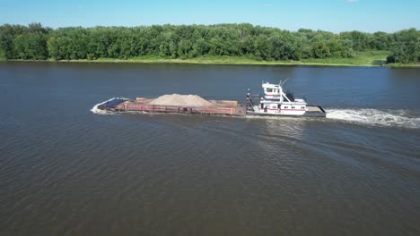 un remolcador empuja una sola barcaza de tierra hacia el norte en el río mississippi más allá de lansing, iowa-4