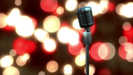 Retro-metallic-microphone-against-red-and-yellow-spots-of-light-against-black-background