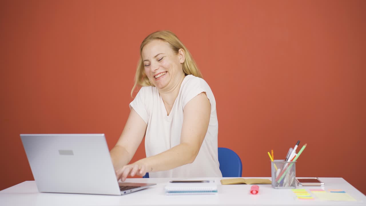 노트북을 보는 여자는 행복하고 춤을 추고 있습니다.