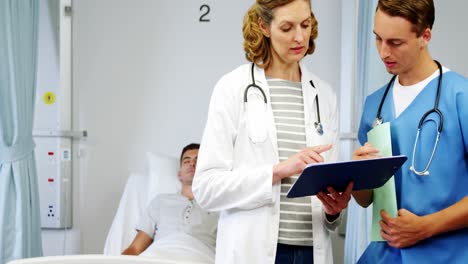 médico y enfermera discutiendo sobre el informe médico
