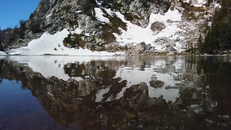 Calm-and-reflective-surface-of-Surprise-Lake-in-Grand-Teton-National-Park-in-Wyoming-on-a-sunny-summer-day