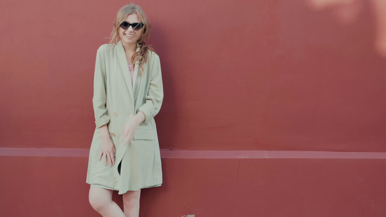 mujer elegante posando frente a una pared roja