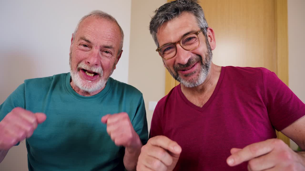 Uomini maturi felici che salutano e ridono durante una videochiamata