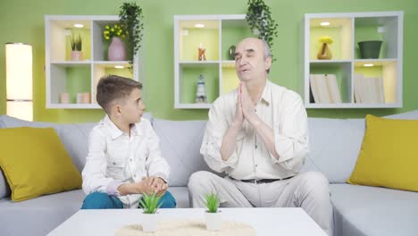 el anciano le enseña al niño a rezar.