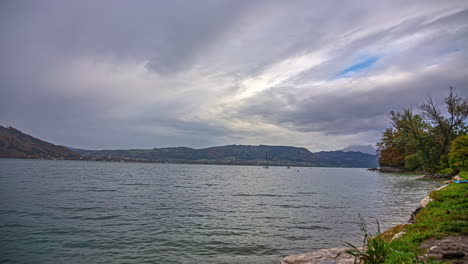 Escena-Tranquila-De-Nubes-Flotando-Sobre-El-Paisaje-Del-Lago-De-Los-Alpes-Austriacos-En-Lapso-De-Tiempo