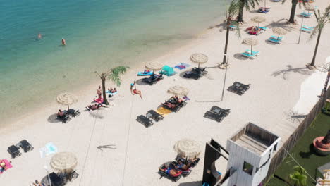 Noa-Zipline---Mutige-Frau-Mit-Selfie-stick,-Die-An-Einem-Sonnigen-Sommertag-In-Kroatien-über-Den-Zrce-strand-Und-Das-Meer-Fährt